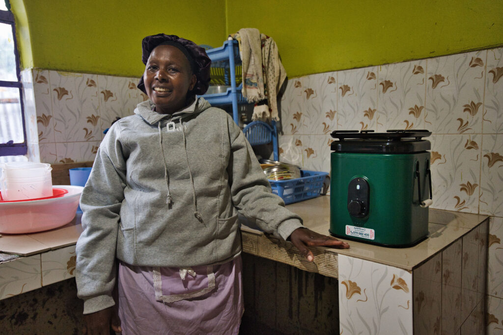 Female customer in Kenya using EcoSafi cookstove – Jason Mulikita for MCFA / Nefco